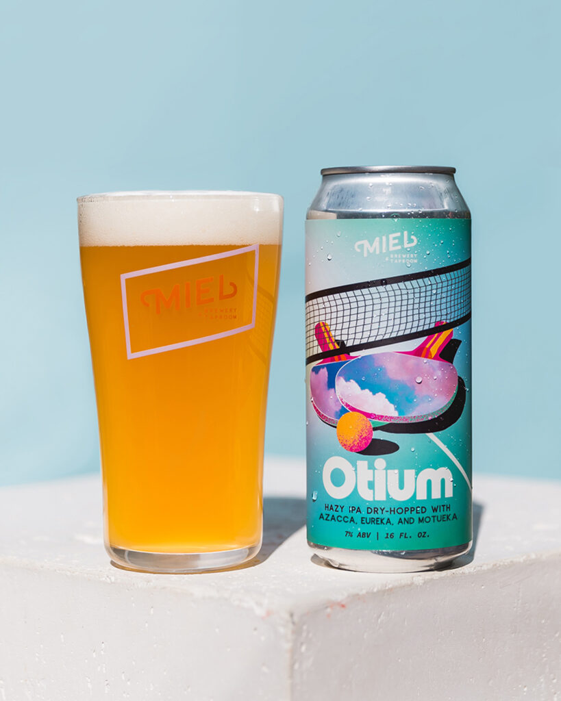 Otium hazy ipa pint next to a 16oz can